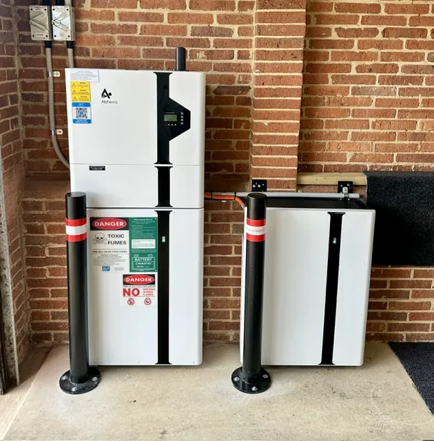 Two home battery cabinets installed side by side behind protective bollards